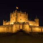 Vista nocturna iluminada del Castillo de Belmonte en verano.