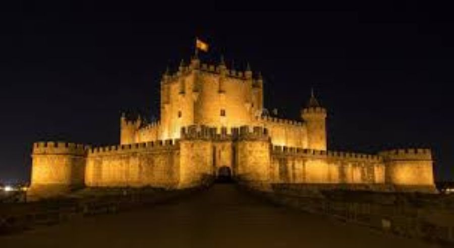 Vista nocturna iluminada del Castillo de Belmonte en verano.