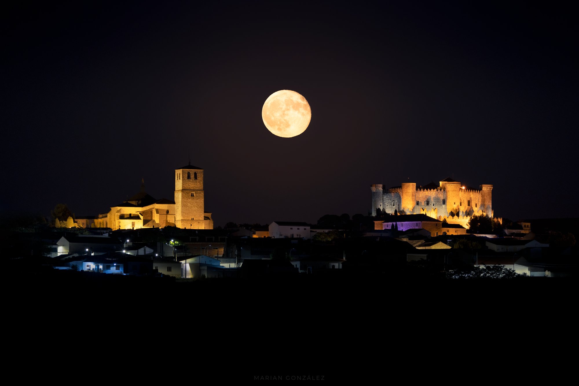 Belmonte de noche con la Colegiata y el castillo iluminados bajo la luna llena